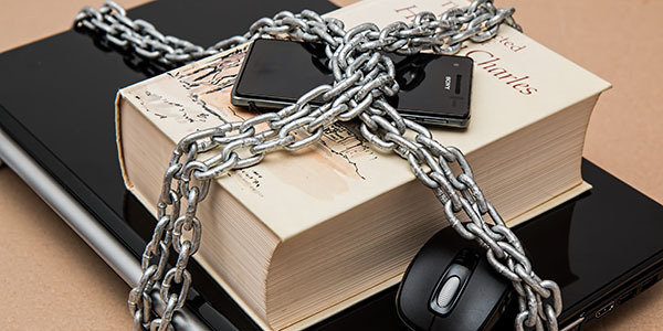 Foto van geketend boek, telefoon en muis voor pc/laptop