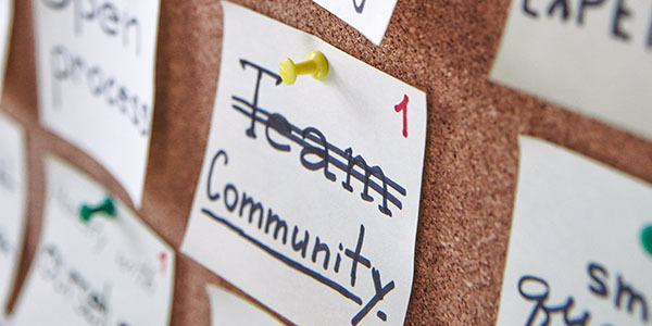 Afbeelding van prikbord met daarop een briefje 'community'