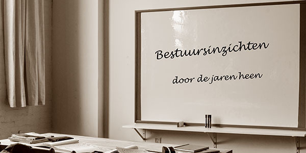 schoolbord-met-daarop-tekst Klaslokaal met schoolbord en daarop de tekst 'bestuursinzichten door de jaren heen'.